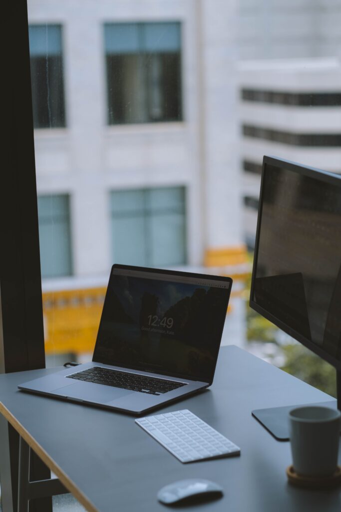A work desk with a laptop computer as well as a monitor